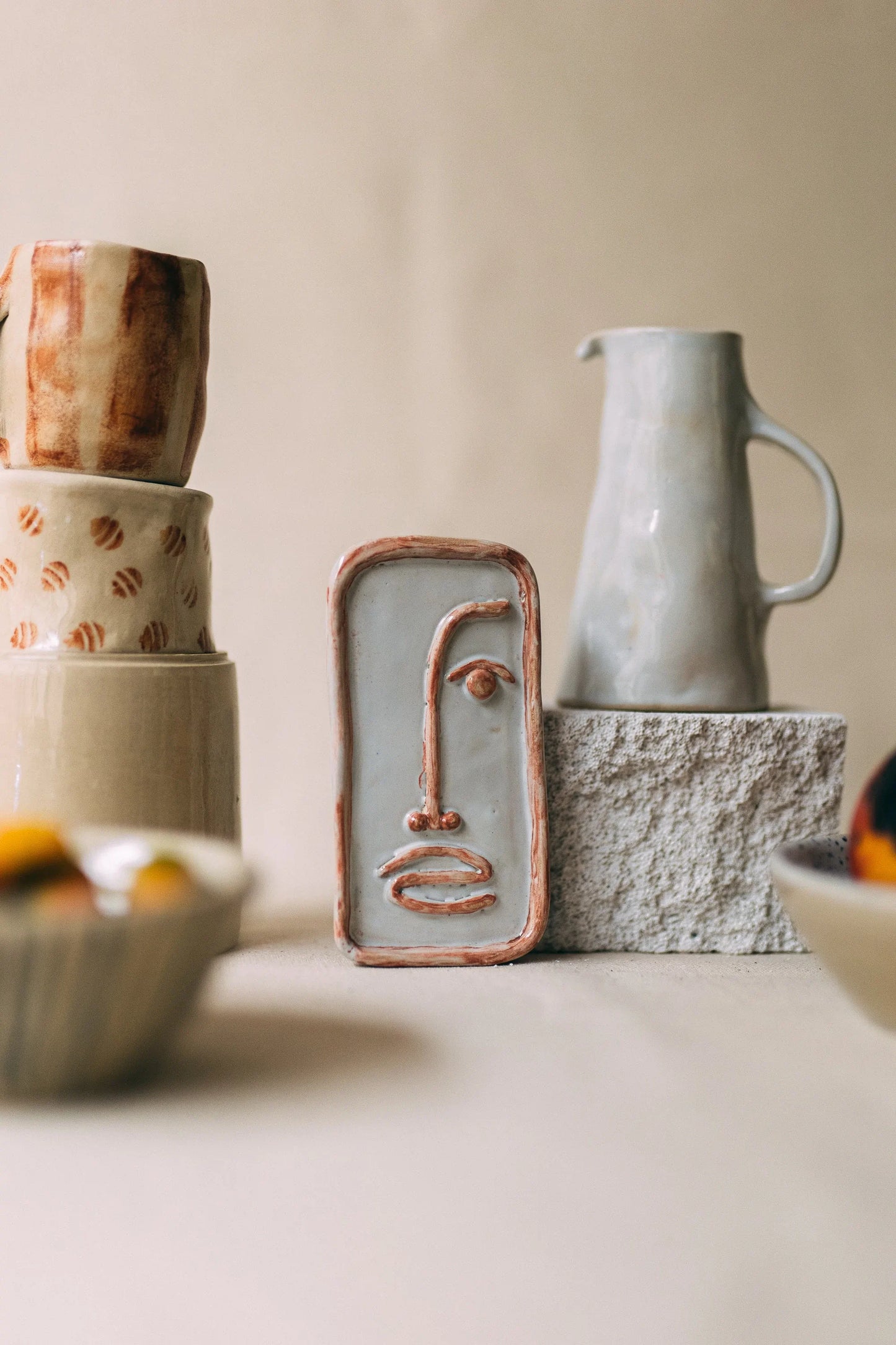 Wystawa rzemieślniczej ceramiki - dekoracyjna płaskorzeźba twarzy, dzbanek, kubki i miski ze wzorami z Zakwas Studio