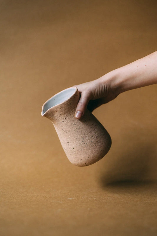 Dłoń prezentująca serwer kawowy ceramiczny w kolorze beżowym