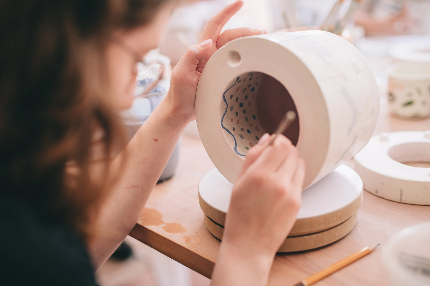 Ręce uczestnika warsztatów dekorujące formę do odlewania porcelany