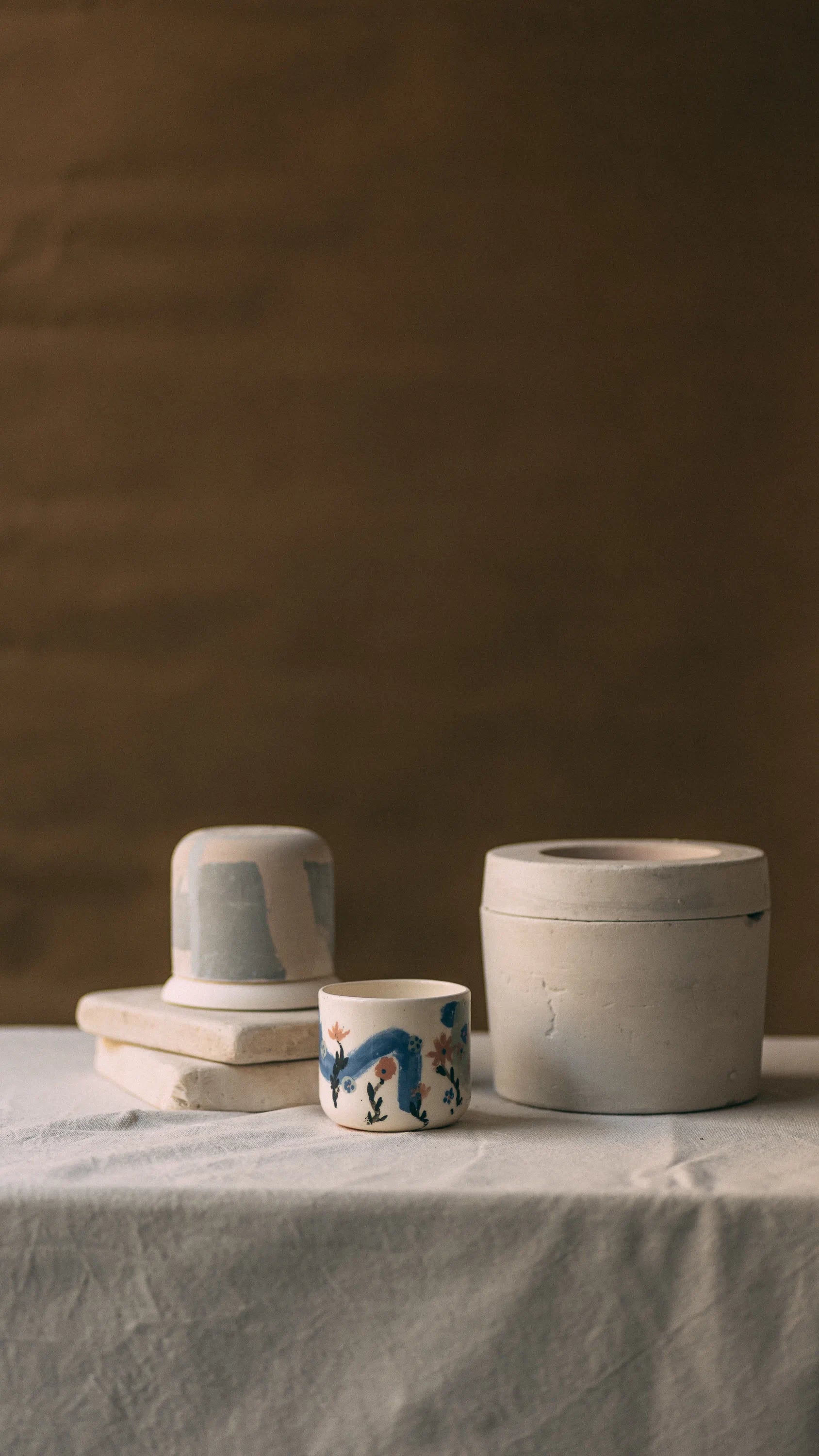 Ręcznie robione ceramiczne wyroby Zakwas Studio - teksturowane naczynia i kubek z ręcznie malowanymi niebieskimi motywami roślinnymi - warsztat odlewania porcelany