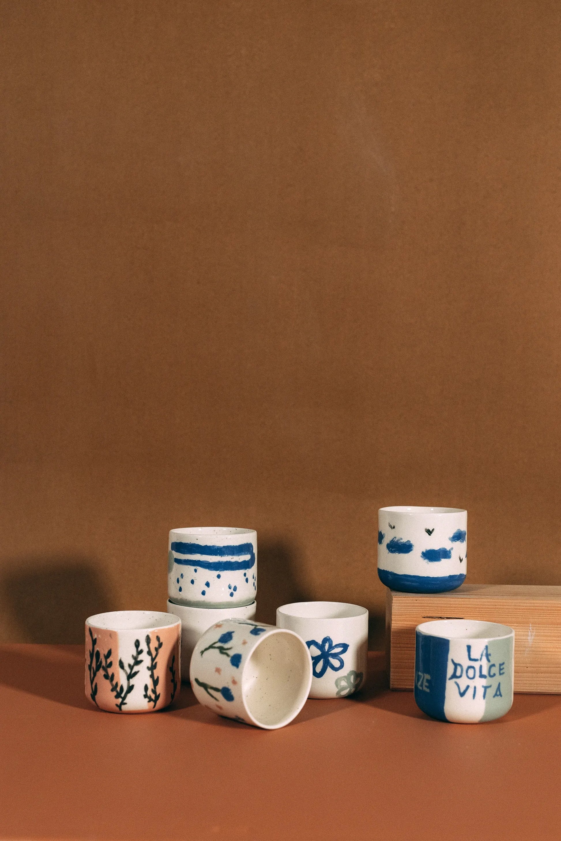 Ręcznie malowane ceramiczne kubki z wzorami roślinnymi, paskami i napisem La Dolce Vita z kolekcji Zakwas Studio