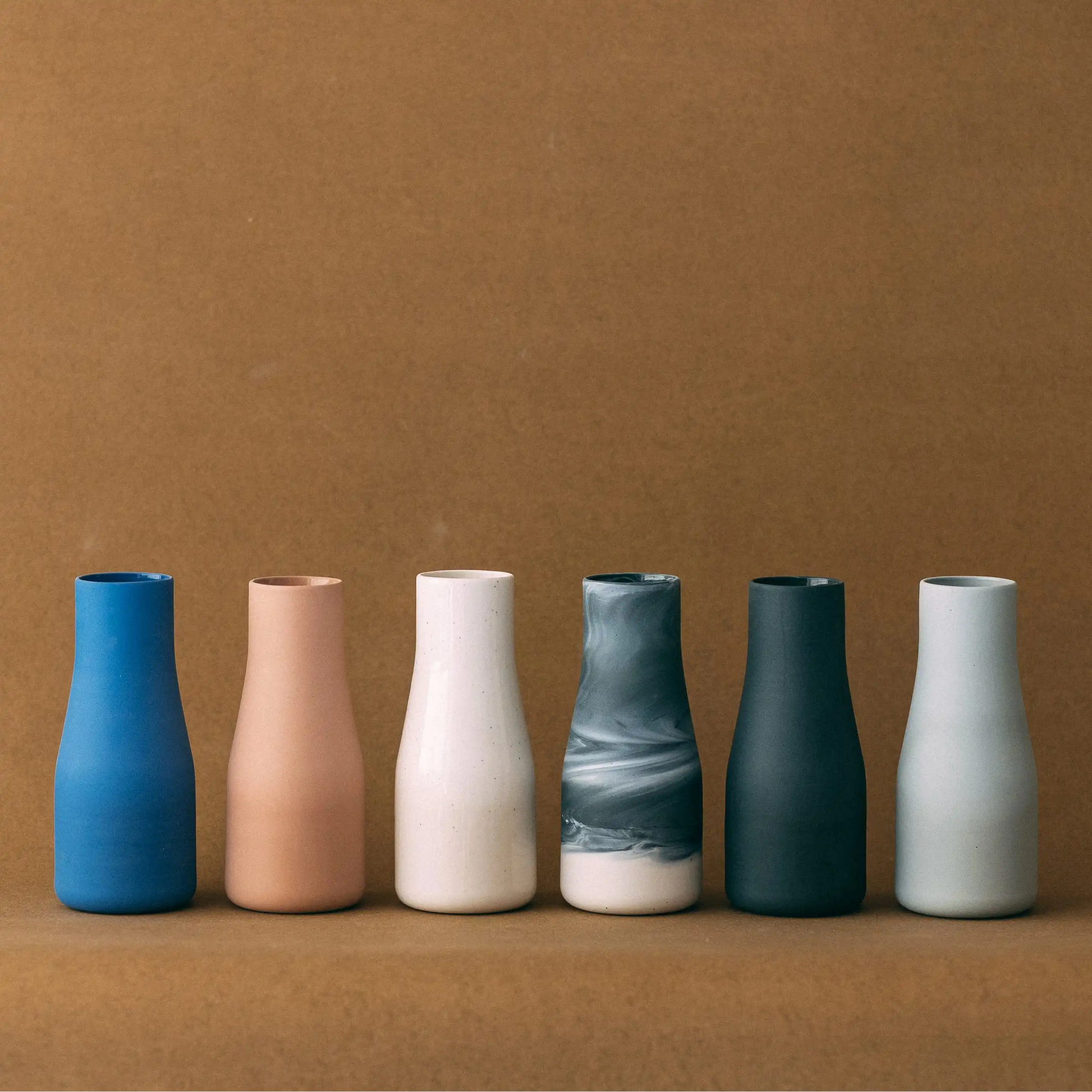 Karafka ceramiczna TAP w różnych wariantach kolorystycznych na jasno brązowym tle