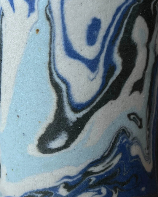 Wypełniające cały kadr zbliżenie na organiczny wzór powstały przy zmieszaniu ze sobą niebieskiej, grafitowej, beżowej i miętowej gliny