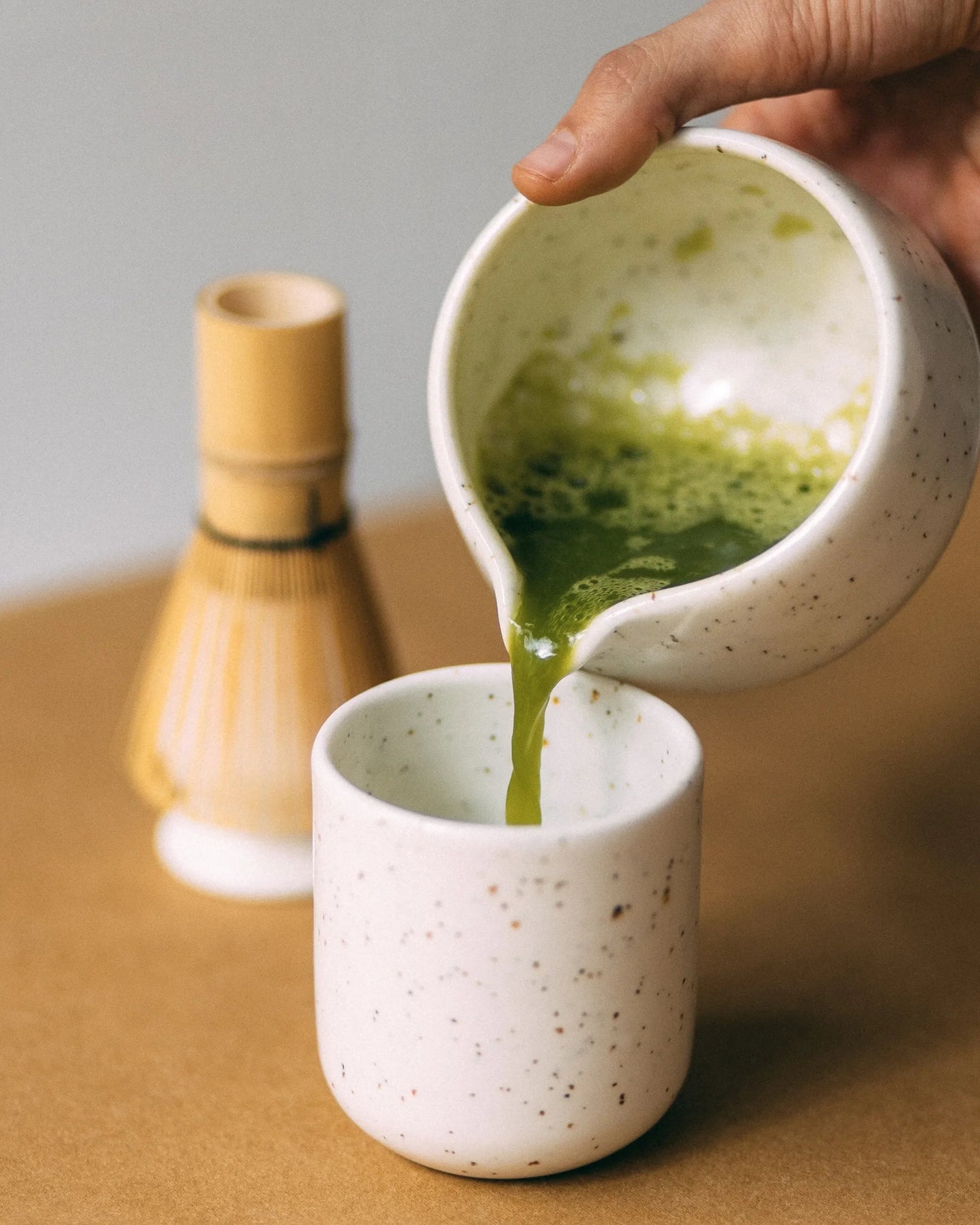 Przelewanie matchy z miseczki z dziubkiem do kubka