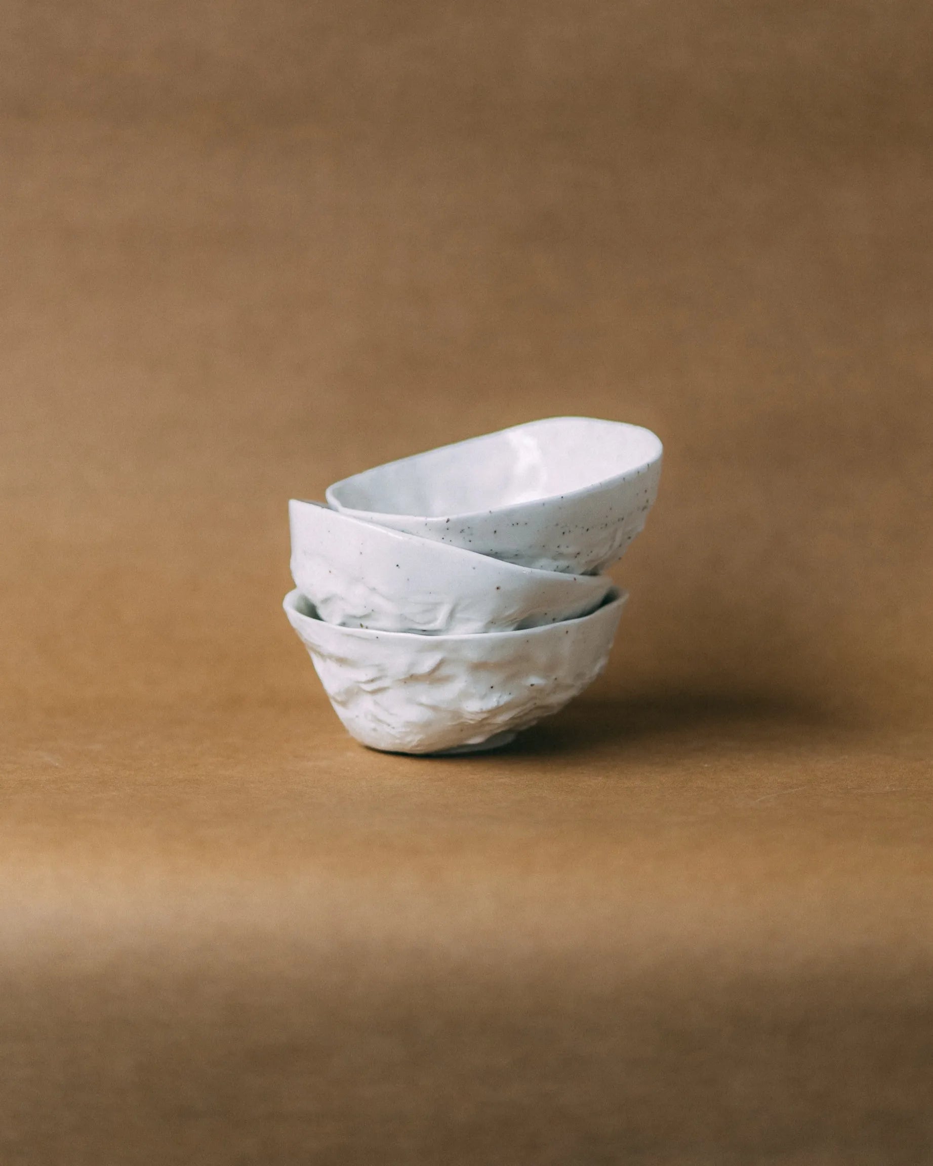 Trzy białe, porcelanowe miski KOS ułożone nierówno jedna na drugiej