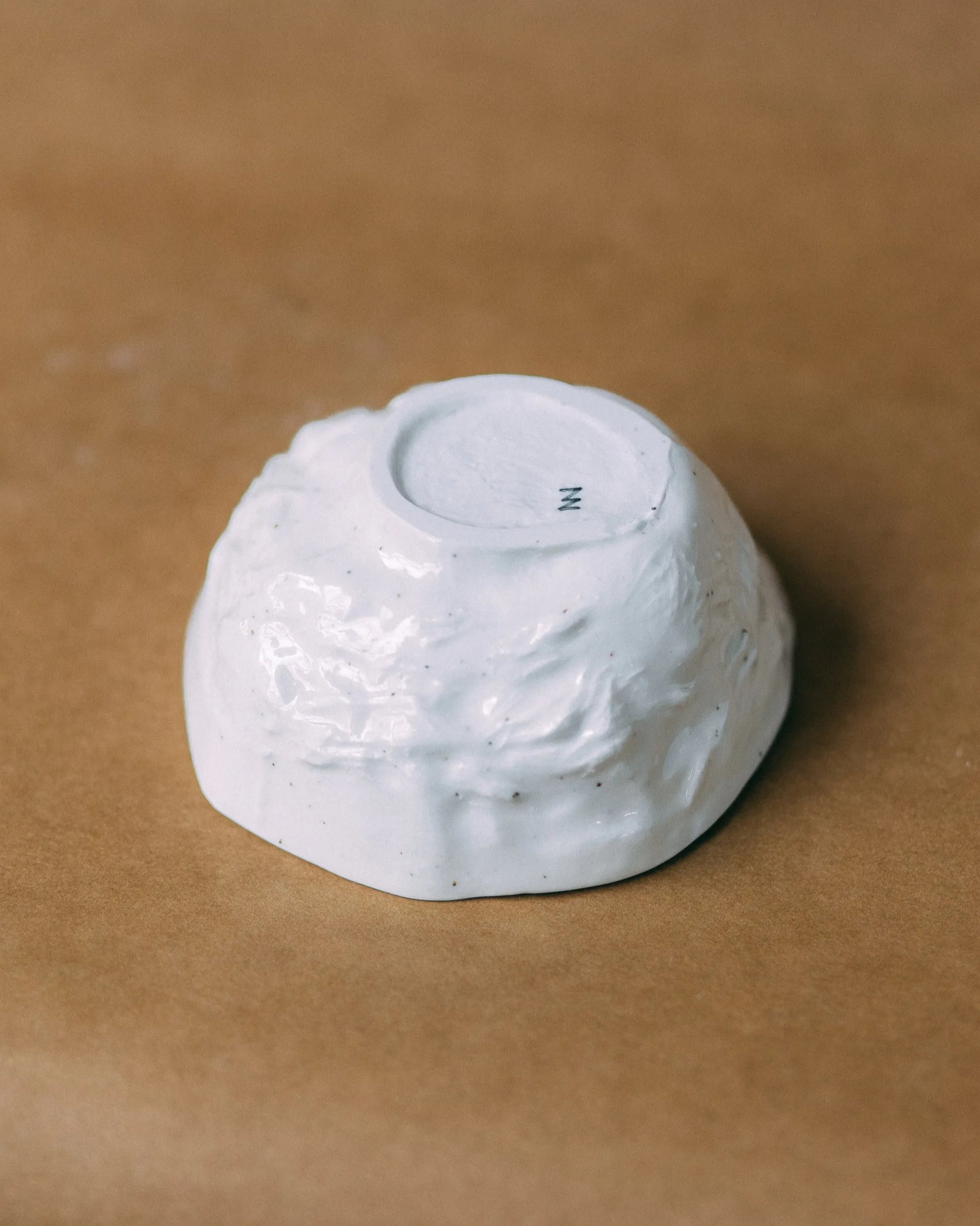 Porcelanowa miska KOS położona dnem do góry, z widocznym, małym logo w kształcie litery zet na stopie naczynia