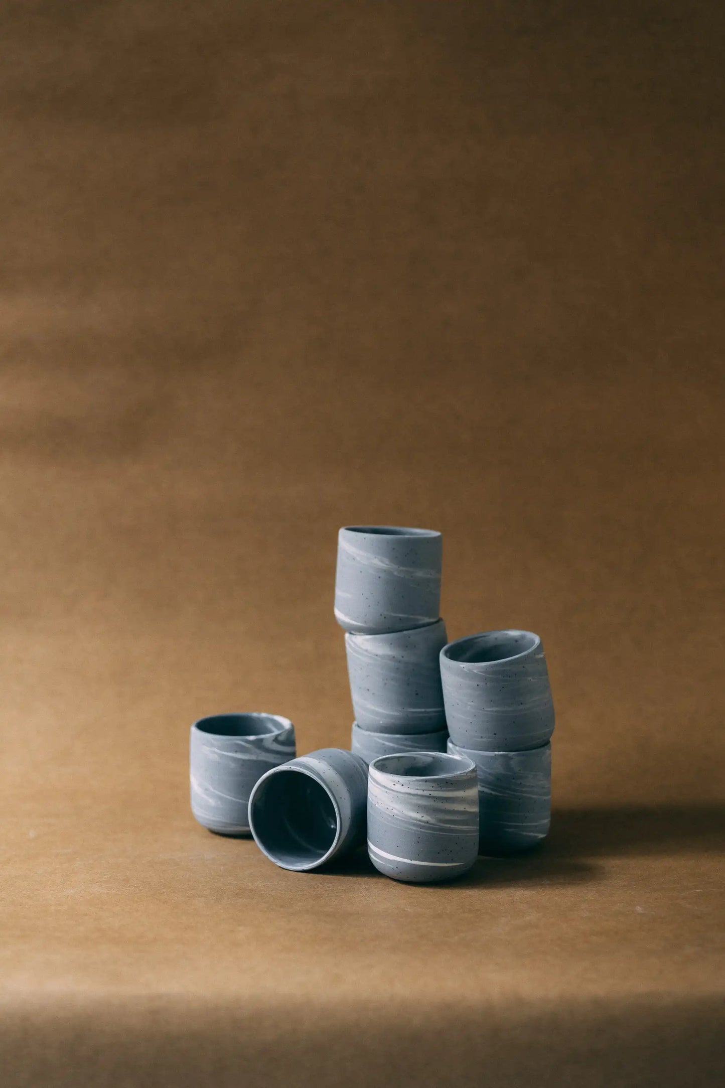 Kompozycja złożona z kilku czarek ceramicznych PopUp BRZASK w marmurkowym kolorze szaro-białym