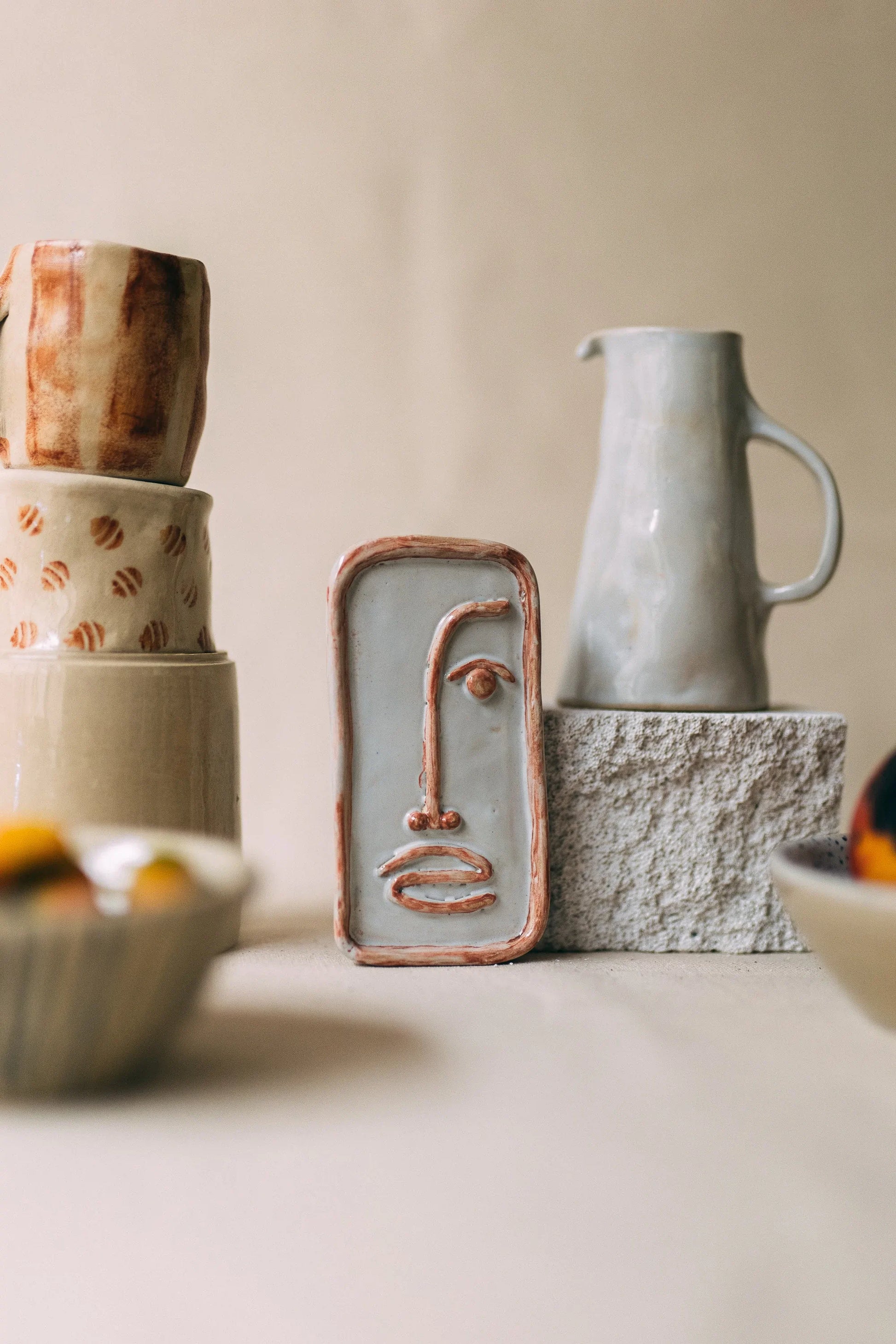 Wystawa rzemieślniczej ceramiki - dekoracyjna płaskorzeźba twarzy, dzbanek, kubki i miski ze wzorami z Zakwas Studio