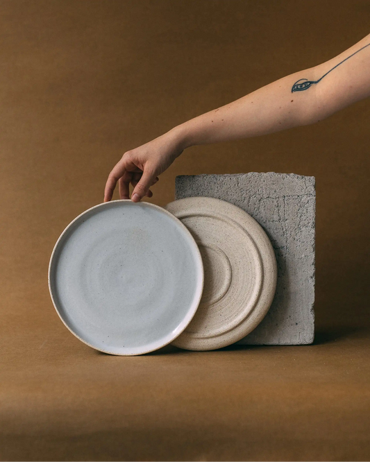 Ręka prezentująca talerze obiadowe ceramiczne w kolorze beżowym - przód i tył