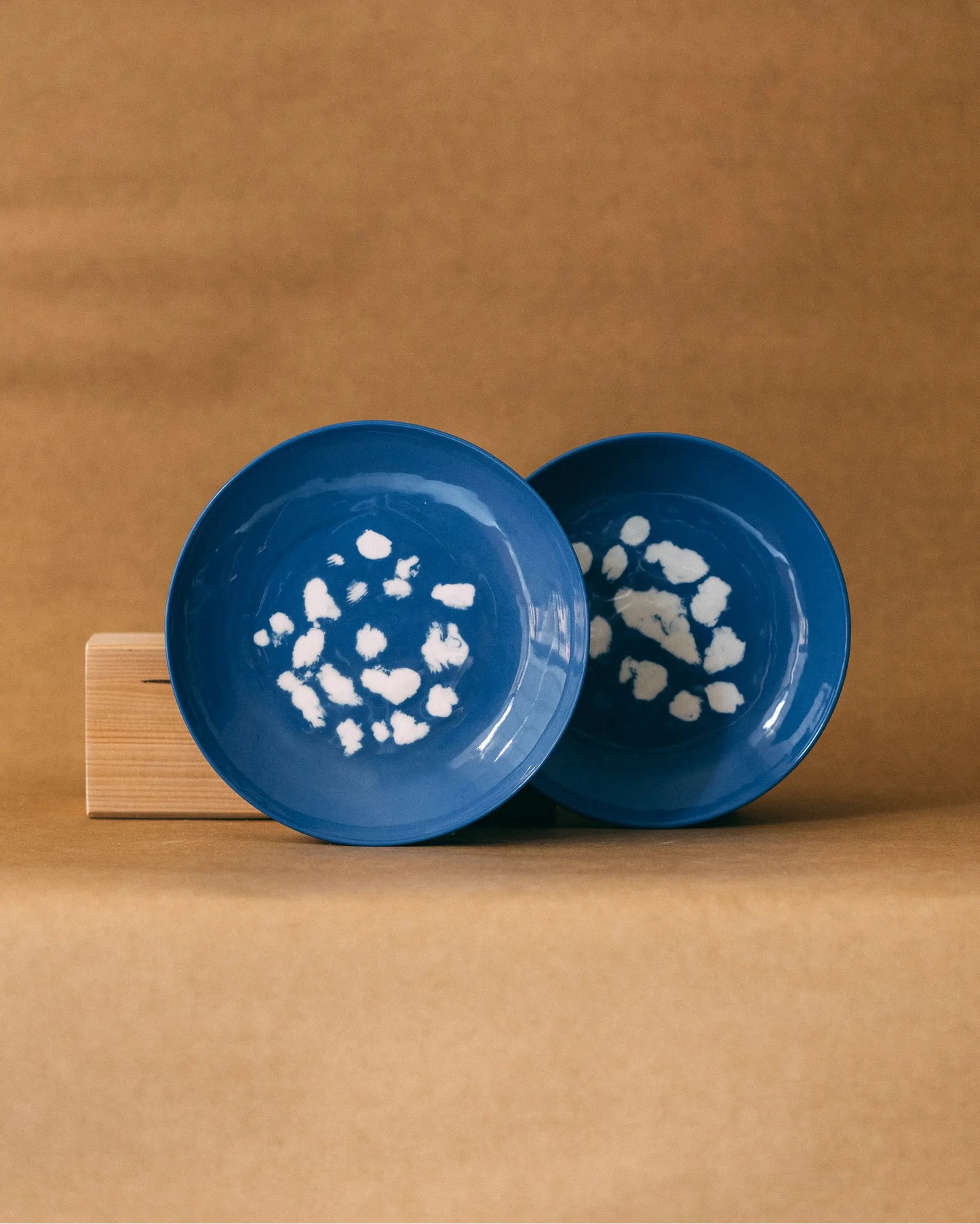 Niebieskie, okrągłe talerze w białe, nieregularne wzory przypominające kropki