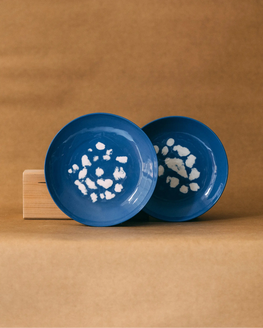 Niebieskie, okrągłe talerze w białe, nieregularne wzory przypominające kropki