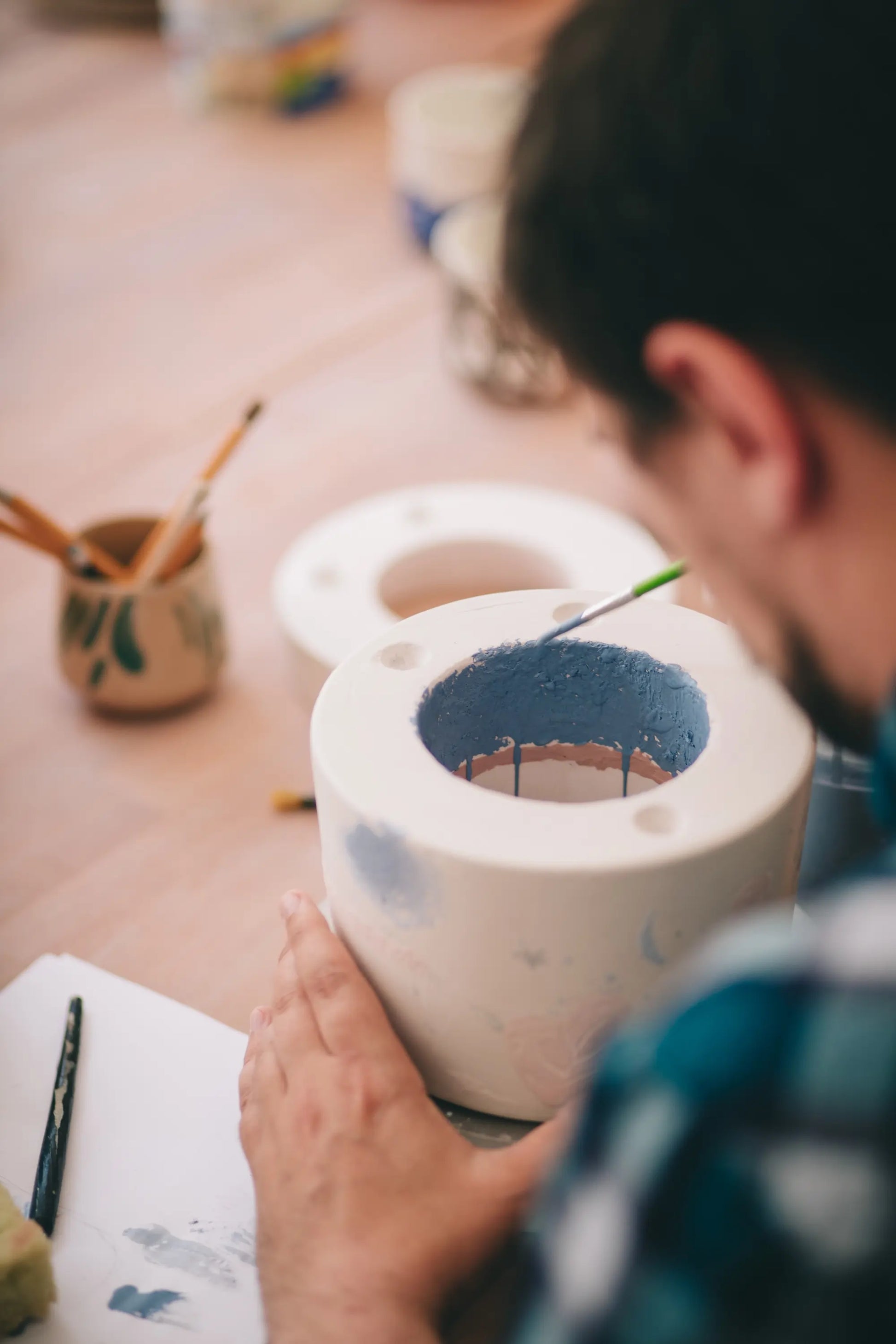 Dłonie precyzyjnie ozdabiające porcelanę podczas warsztatu w Zakwas Studio - warsztat odlewania porcelany