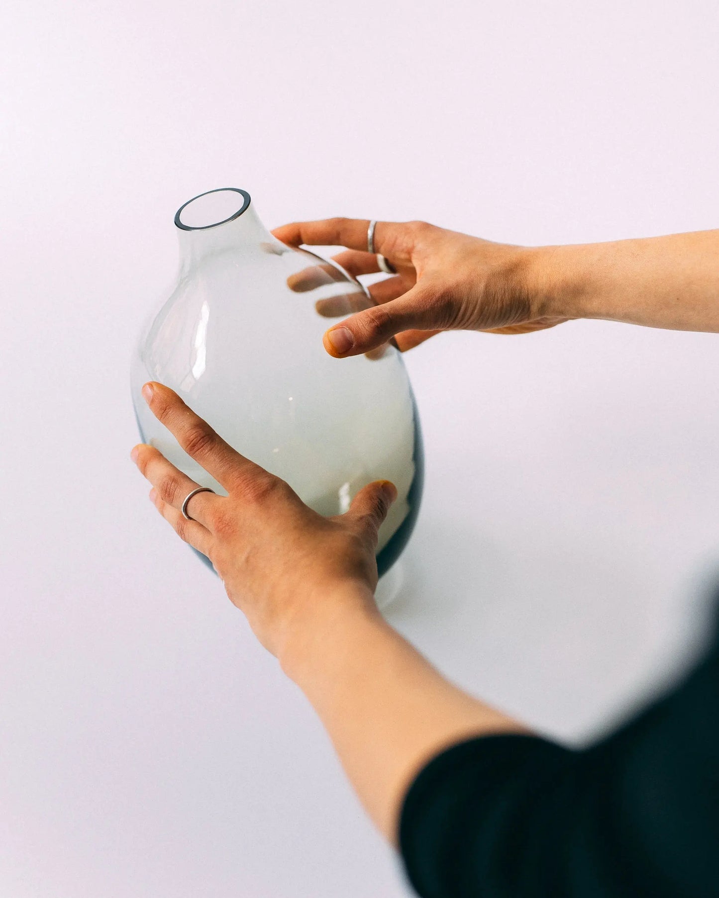 Ręce trzymające szklany wazon Ganna Glass w odcieniu zieleni - artystyczne szkło dekoracyjne