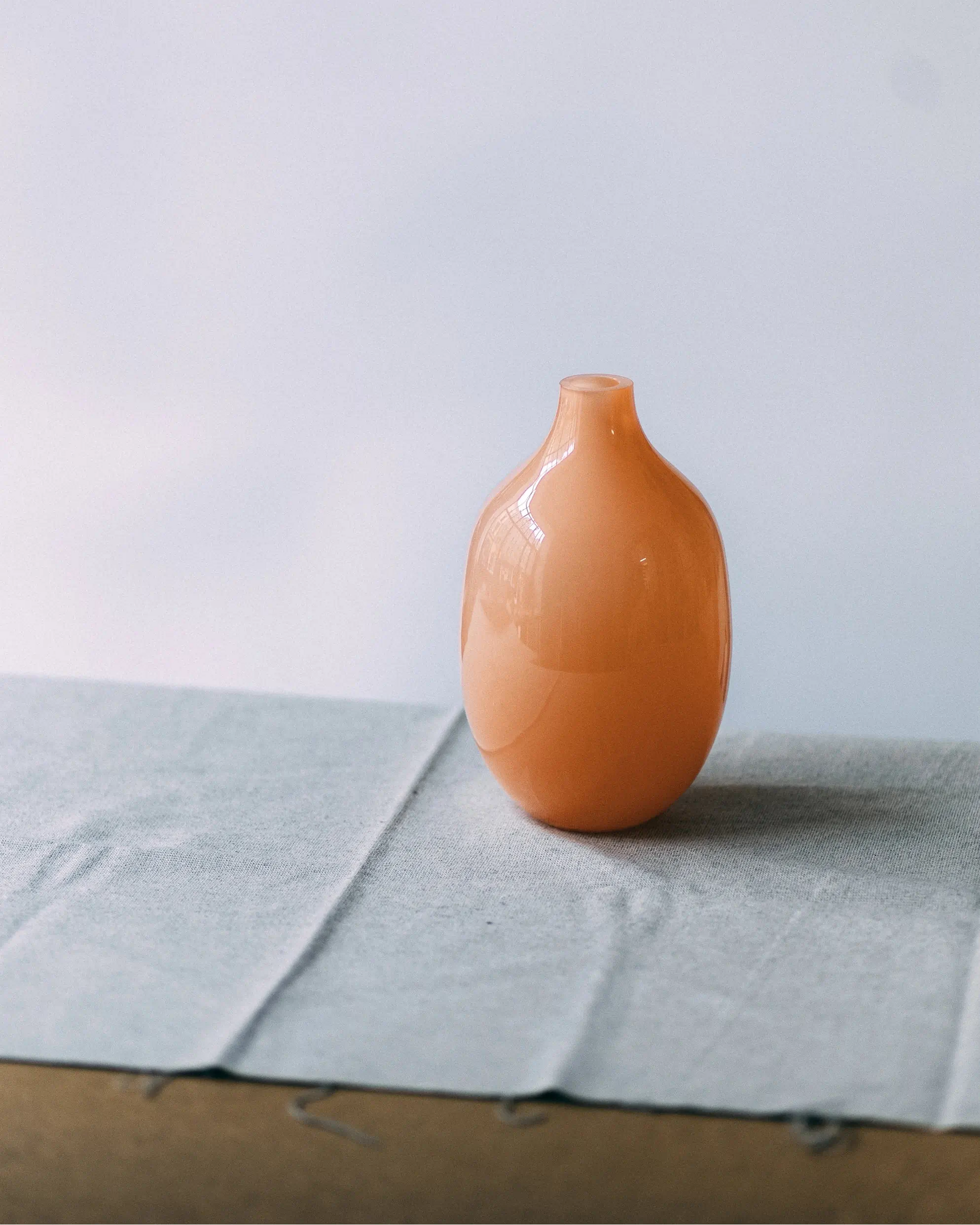 Artystyczny wazon Ganna Glass w brzoskwiniowym odcieniu na jasnym tle - unikalne szkło dekoracyjne