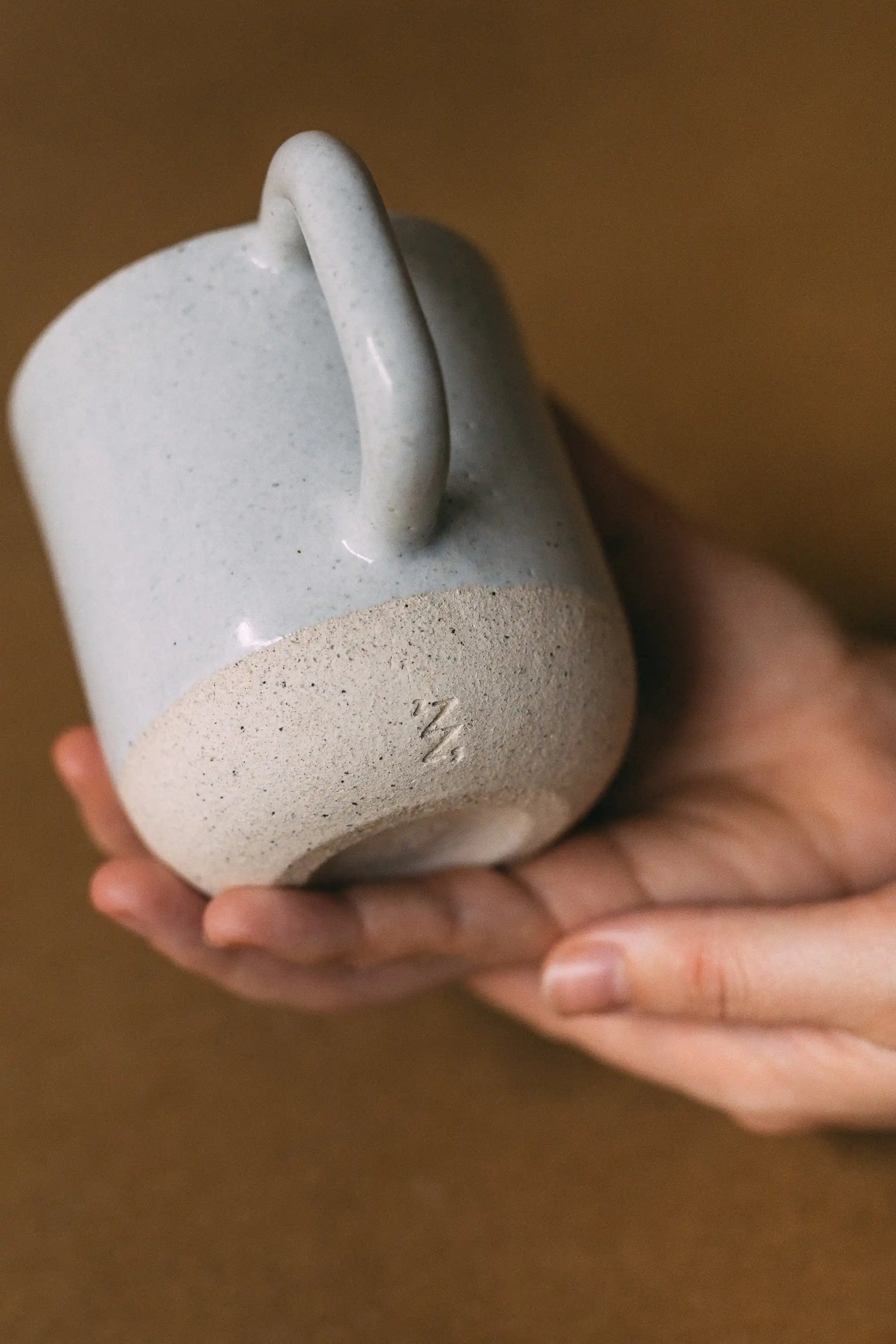 Kubek ceramiczny z uchem w kolorze beżowym - widok z dołu